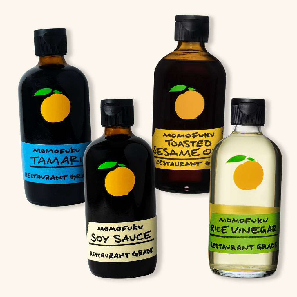 a line of four bottles. from left to right: tamari, soy sauce, toasted sesame oil, rice vinegar.